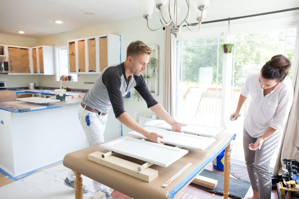 Carpenters assembling a white cabinet in a bright home