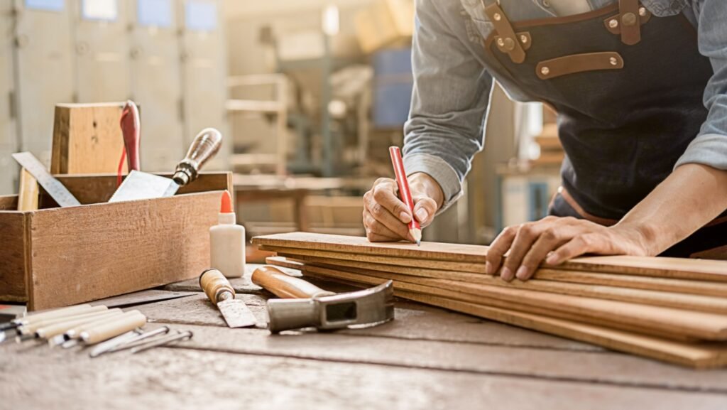 Carpenter marking wood boards on a workbench