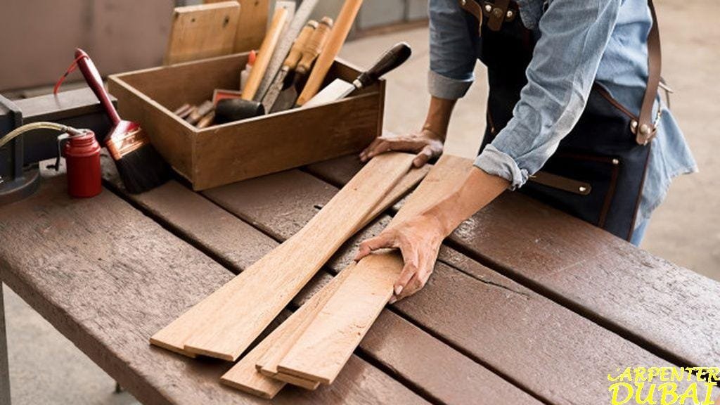 Carpenter sorting wood boards on a workbench