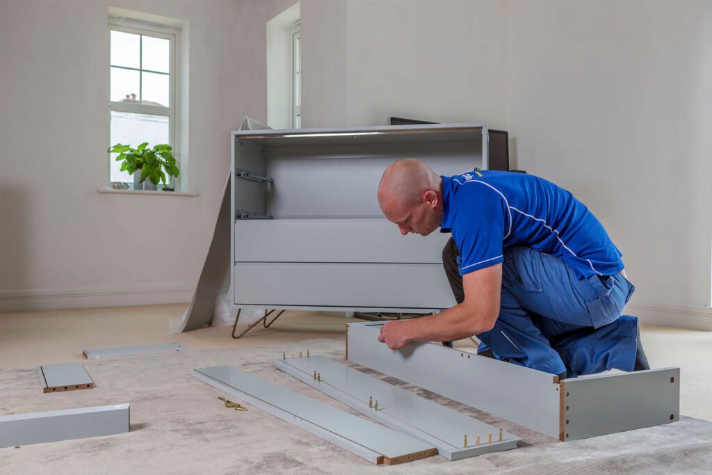 Handyman assembling a gray dresser