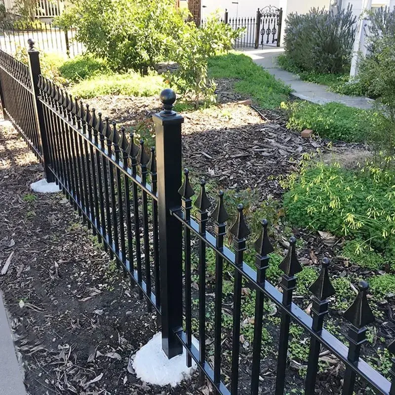 Black metal garden fence installed along a planting bed