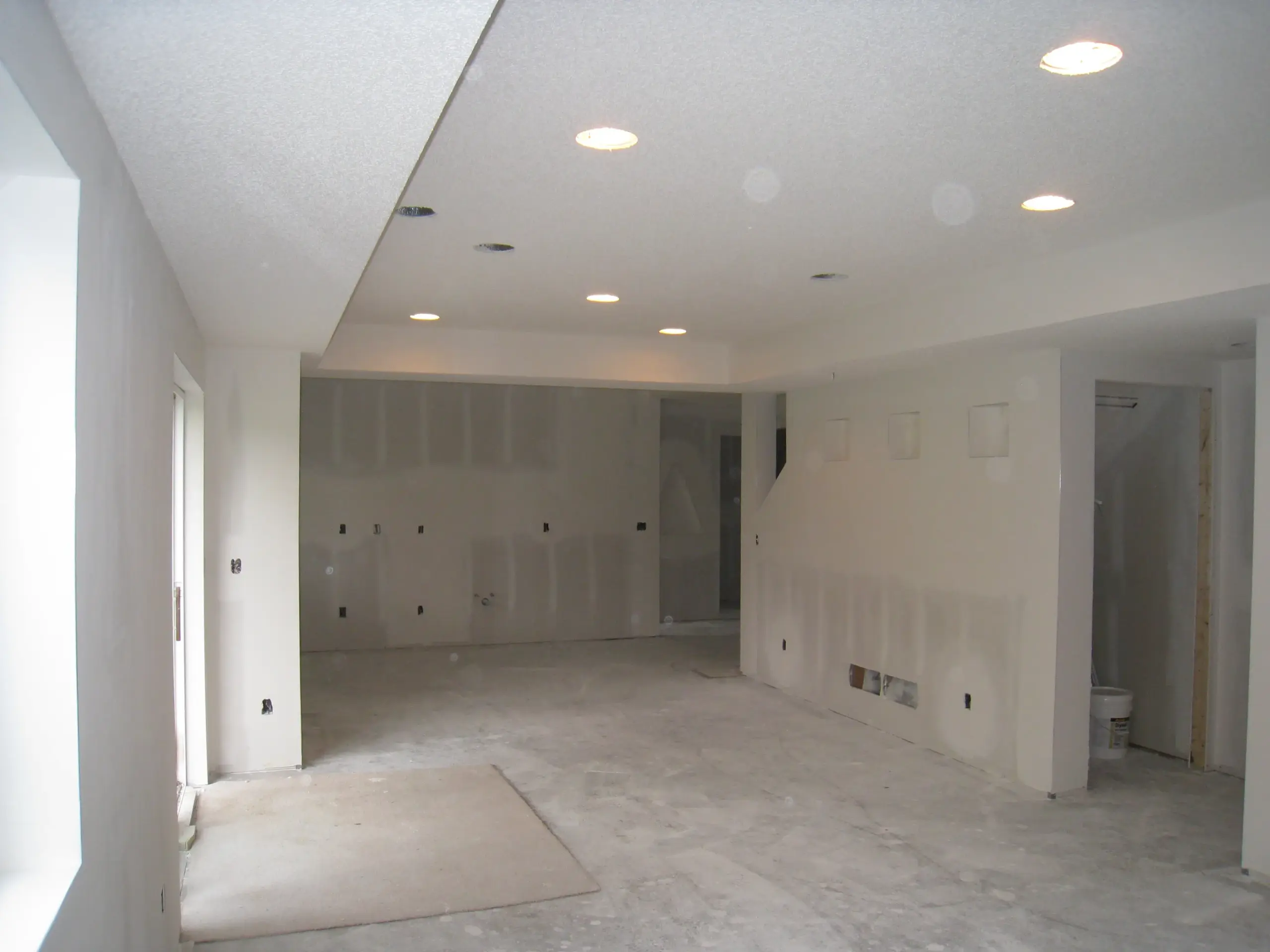 Finished basement with new drywall and recessed lighting