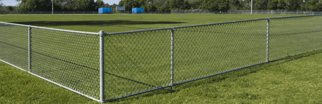 Galvanized chain link fence around a grassy field