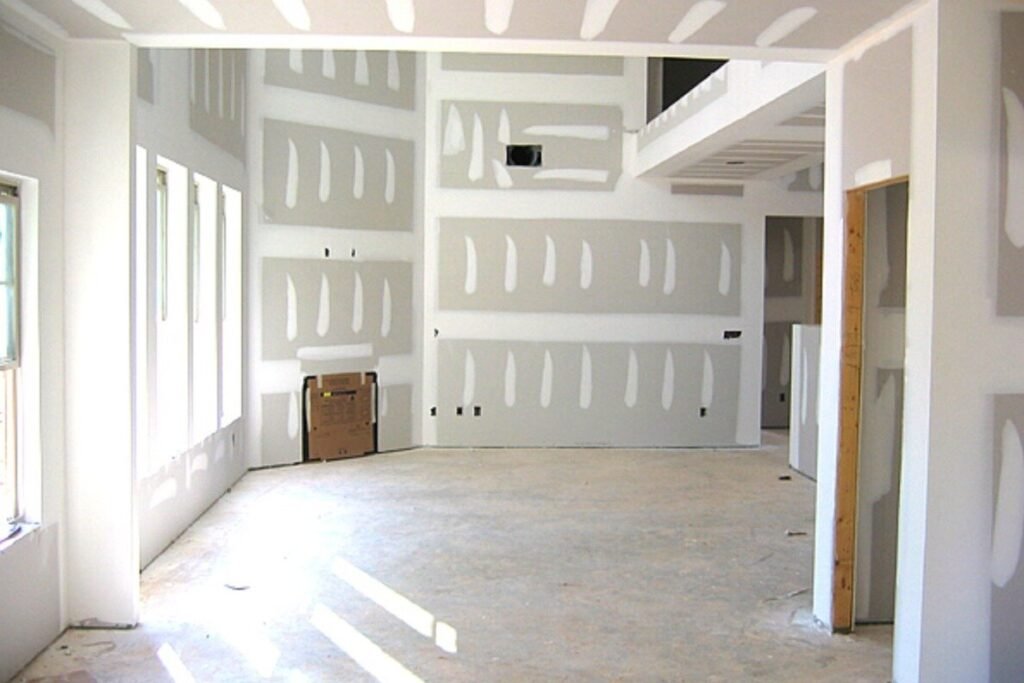 Open room with taped and mudded drywall