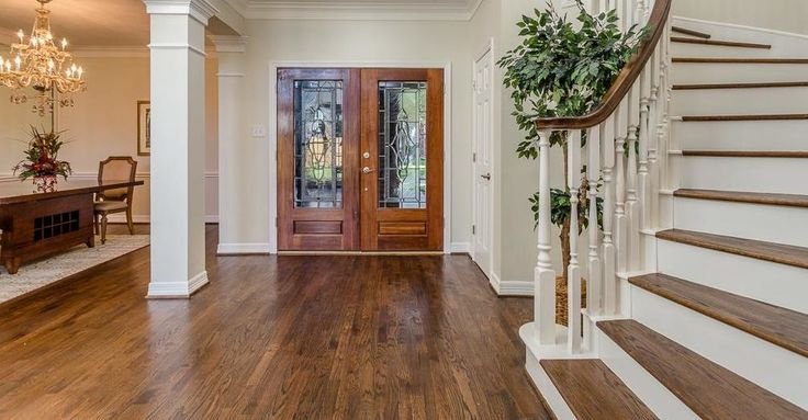 Entryway with hardwood floors, a staircase and wood doors