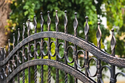 Close-up of an ornamental wrought iron fence with spear finials