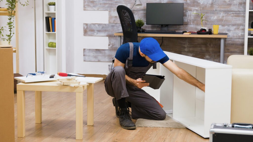 Handyman assembling a white desk in a home office